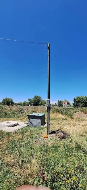 Poste de empalme en un terreno con cámara de registro al pie