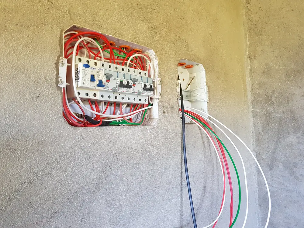 Tablero nuevo embutido junto a una caja con los cables de una derivación nueva