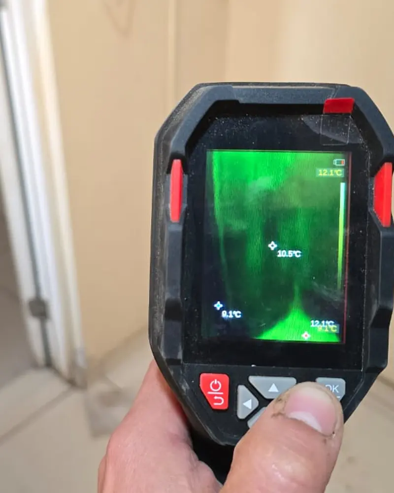 Pantalla de la cámara termográfica con una franja más fría que marca la humedad