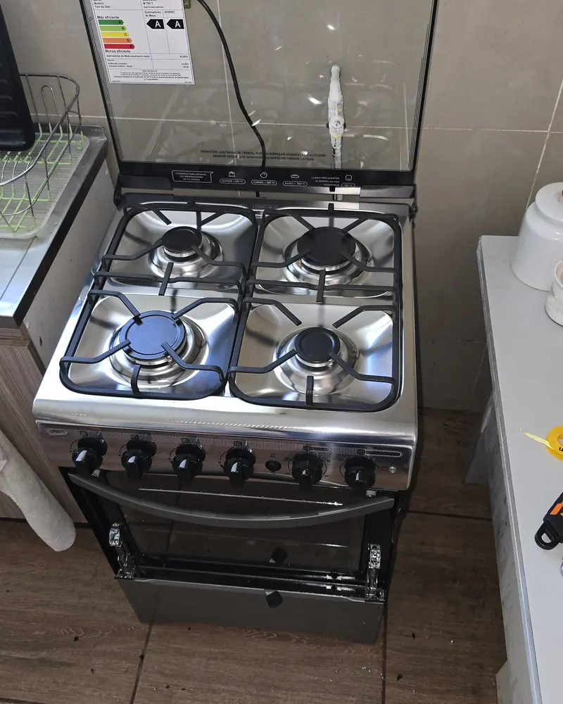 Cocina a gas con sus quemadores sobre piso de madera