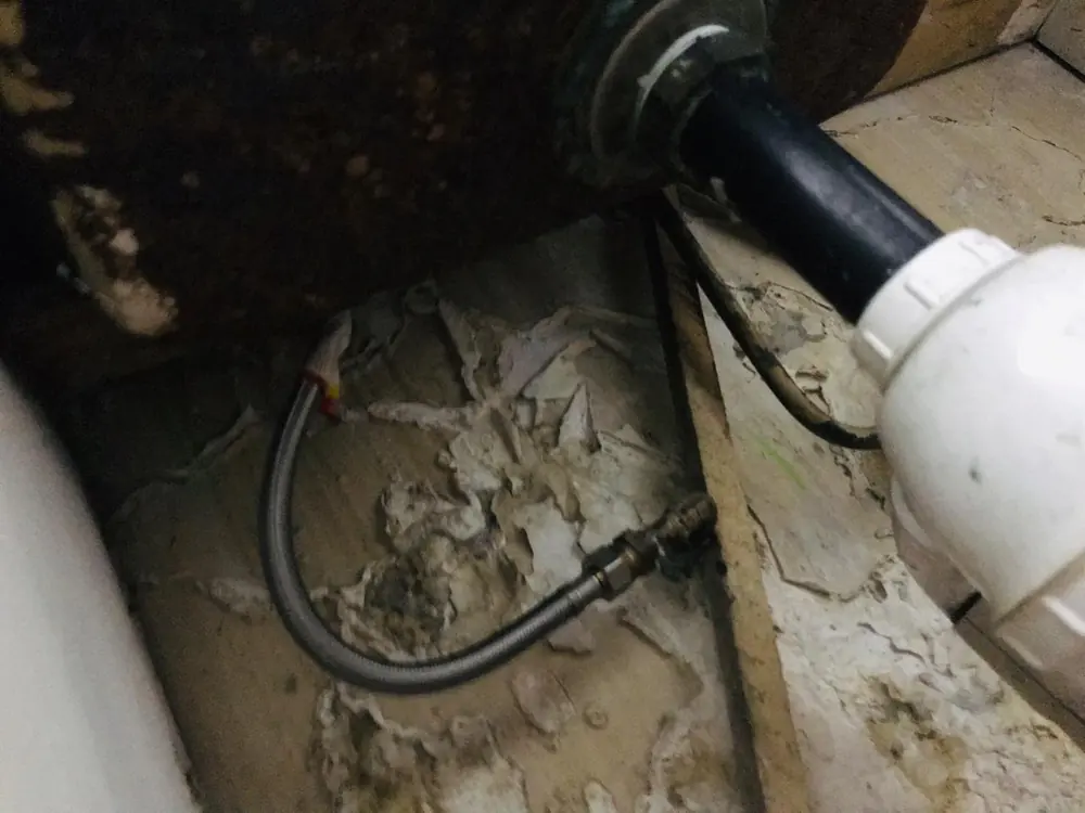 Flexible deteriorado dentro de un mueble con la base húmeda