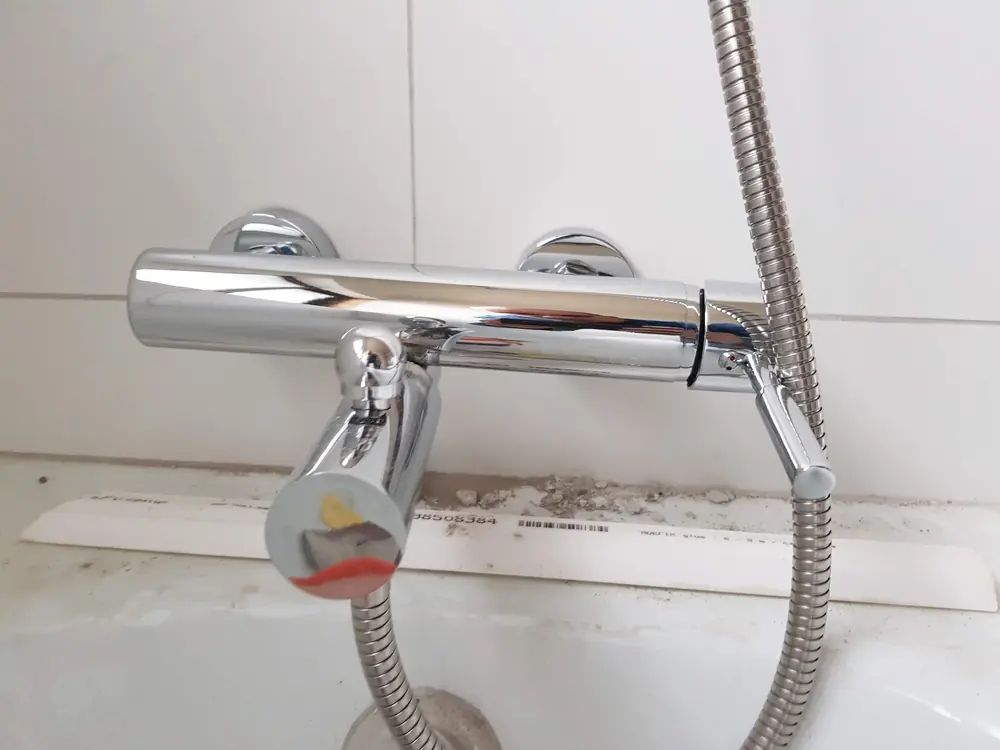 Mezcladora termostática cromada instalada sobre una tina