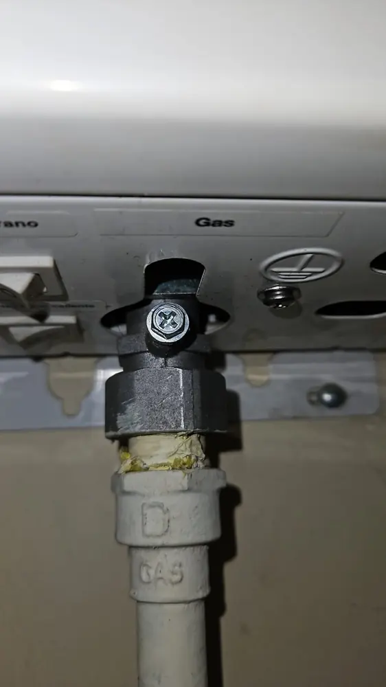 Llave de paso de gas bajo un artefacto, con la cañería que la alimenta